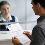 client serre un relevé bancaire devant guichetier