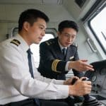Formateur guidant un apprenti conducteur dans cabine locomotive