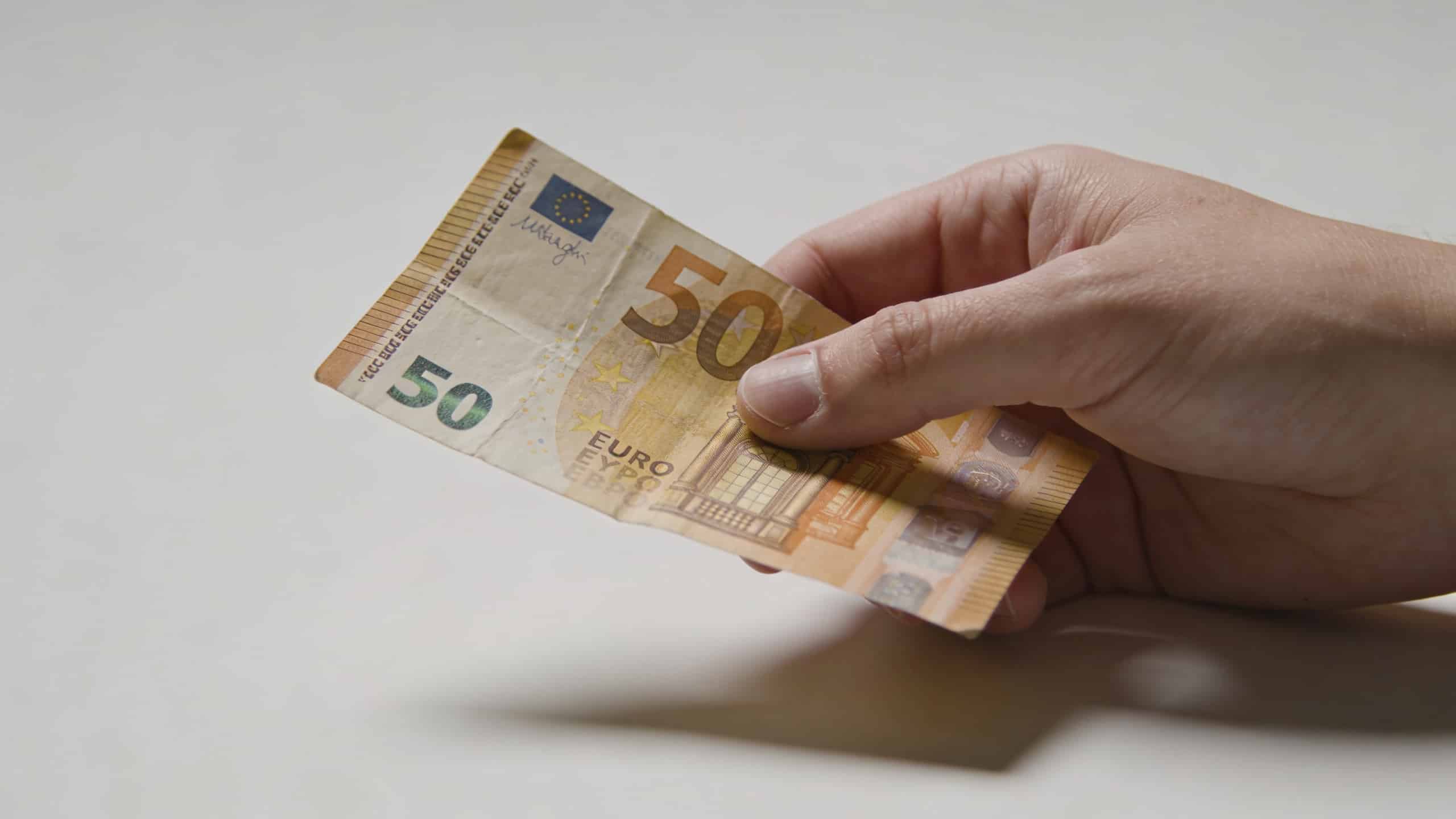 Main declient posant un vieux billet 50 euros