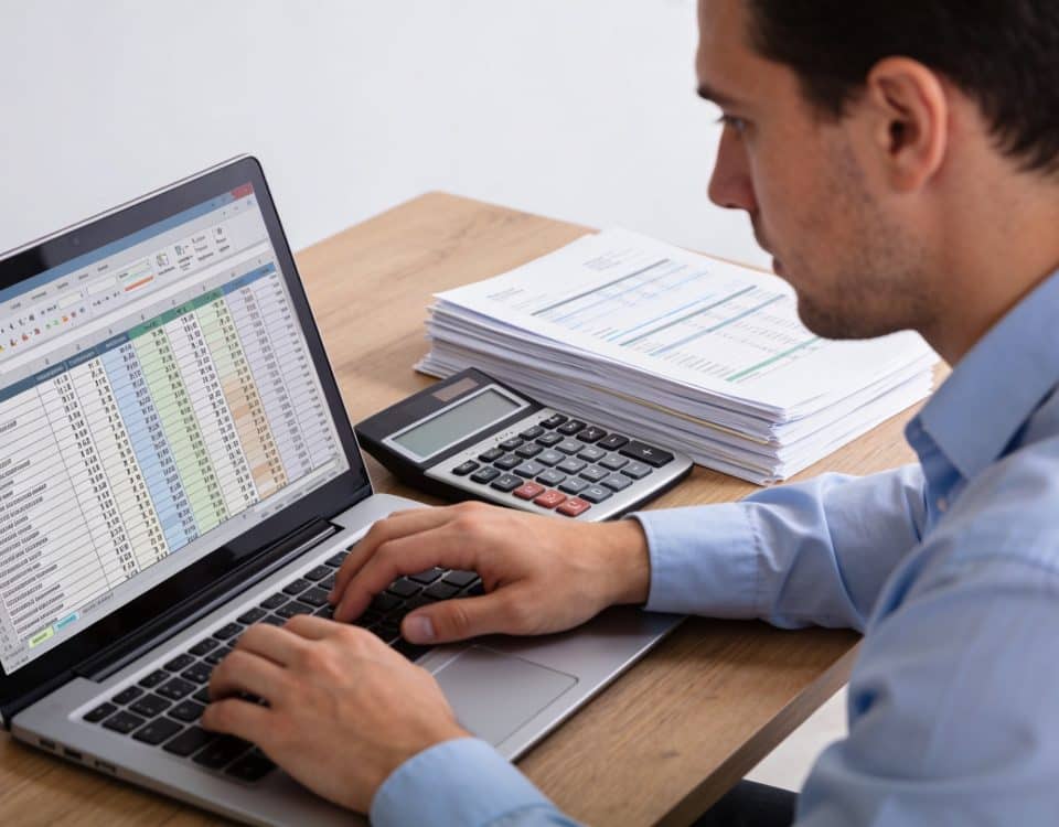 comptable calculant amortissement sur ordinateur avec tableau chiffres