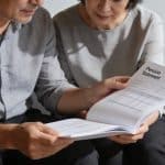 couple age assis sur banc consultant releve de pension