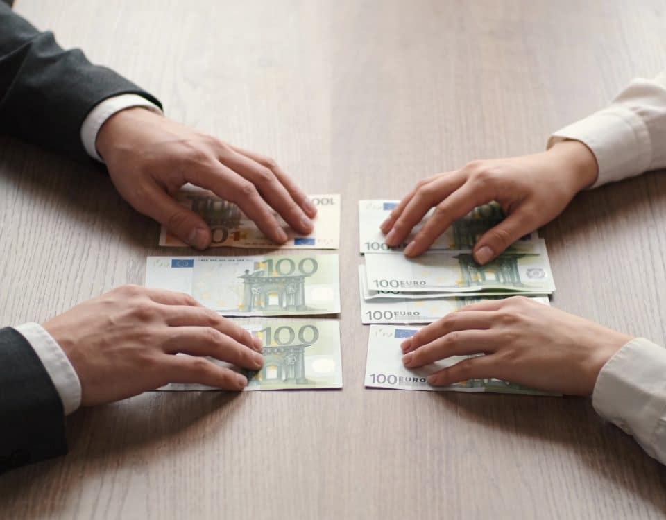 Couple assis a table comptant des billets euro