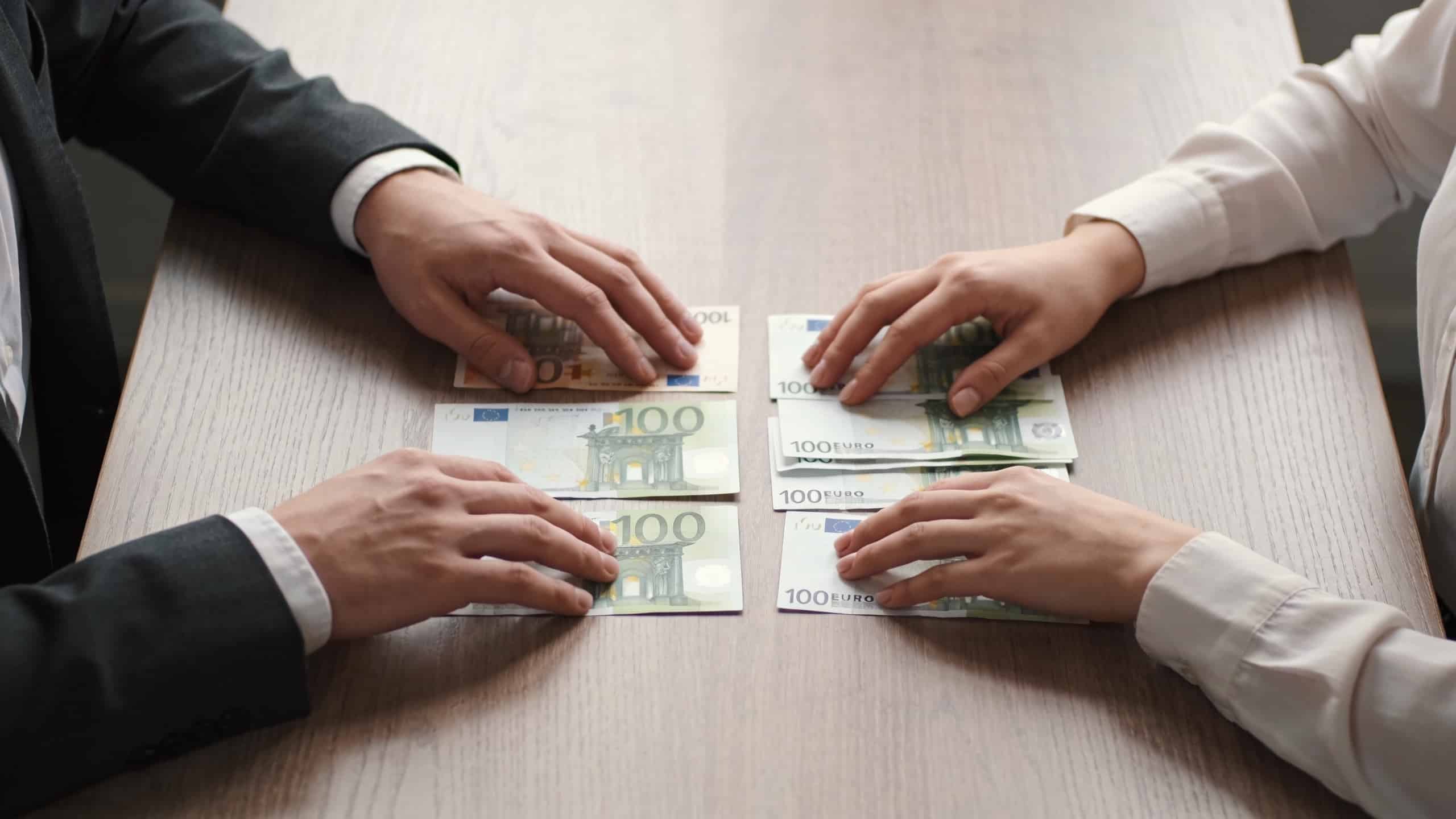 Couple assis a table comptant des billets euro
