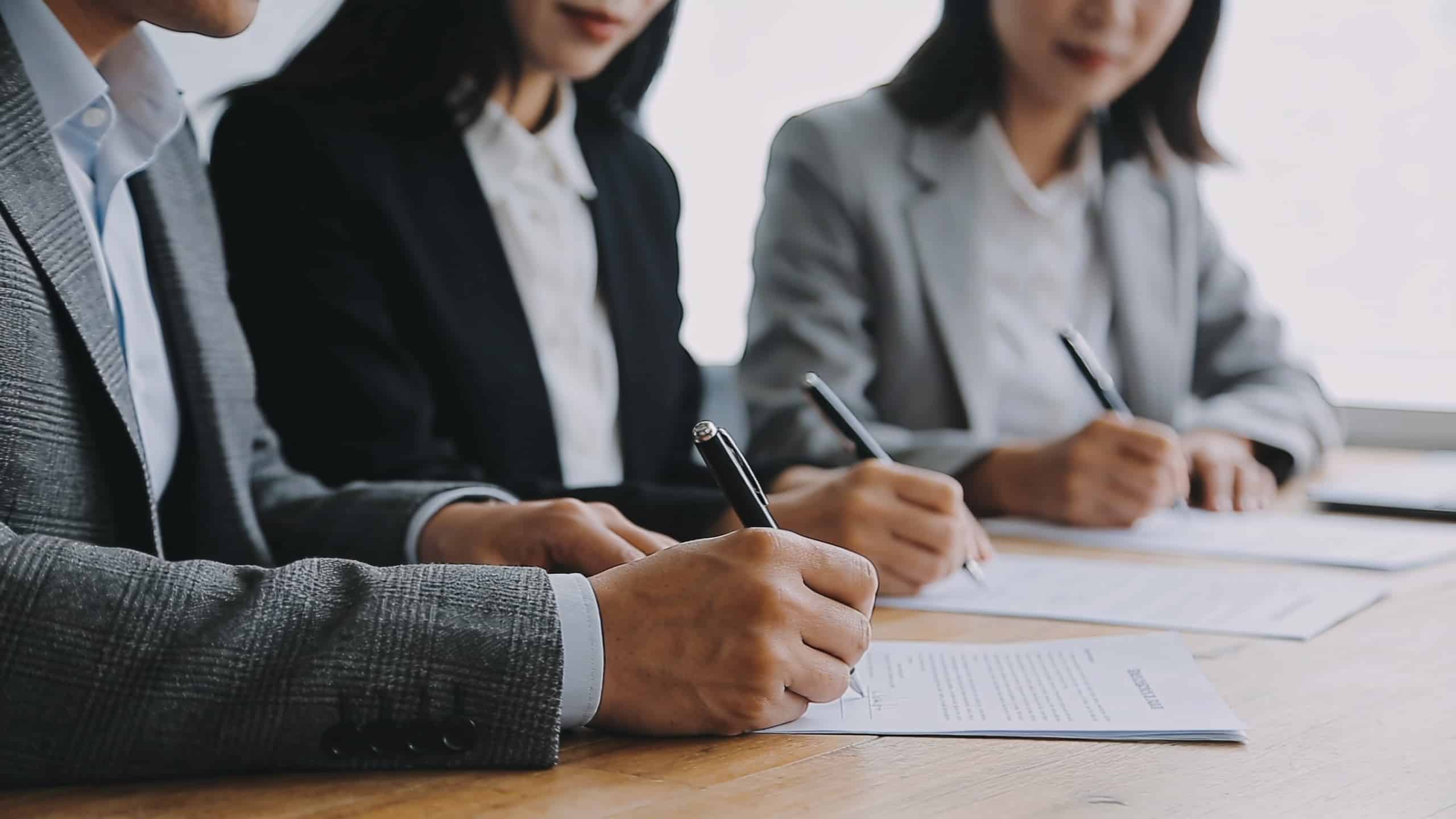 Dirigeants assis autour dune table signant contrat
