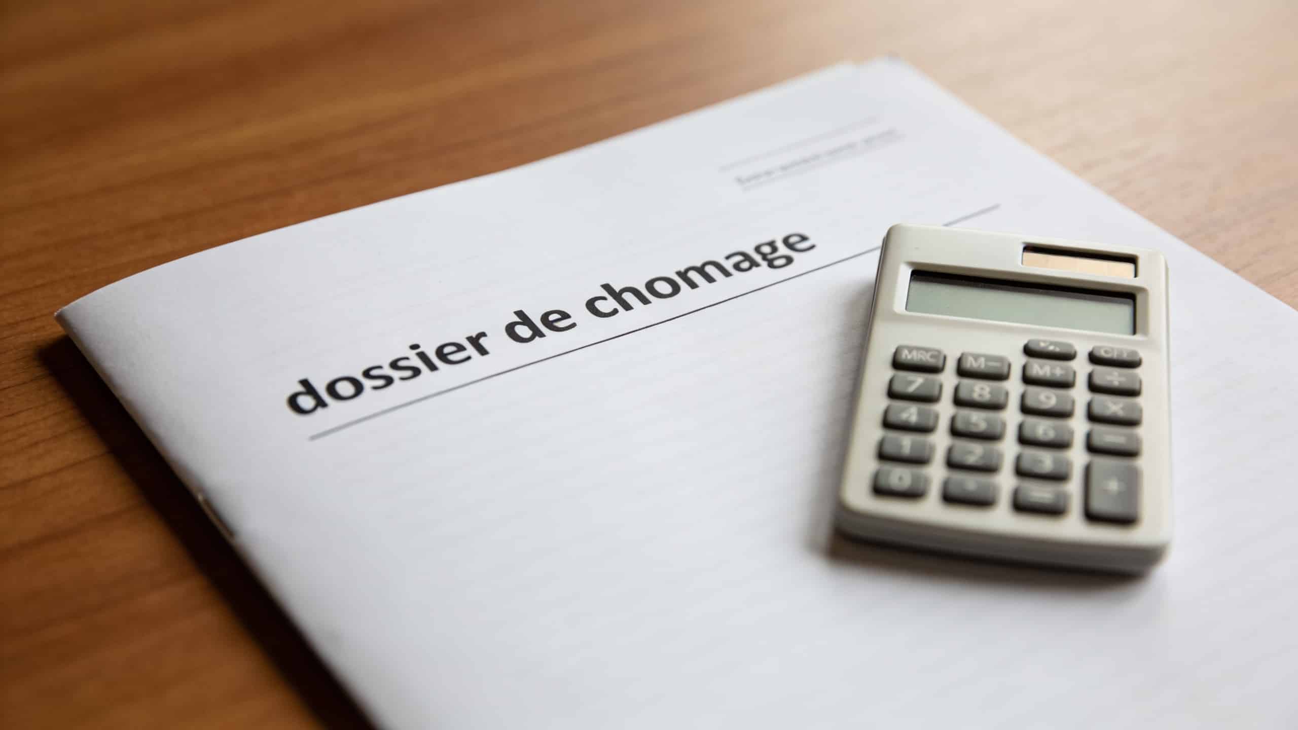 dossier de chomage et calculatrice sur bureau