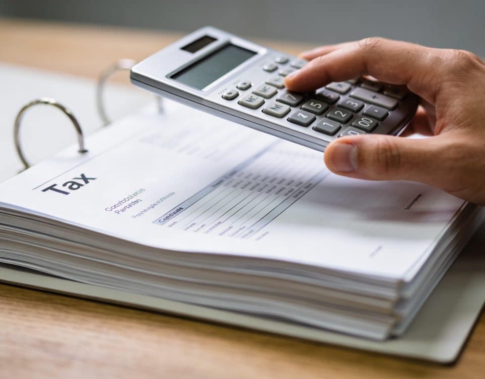 Dossier fiscal ouvert sur bureau, main tenant calculatrice