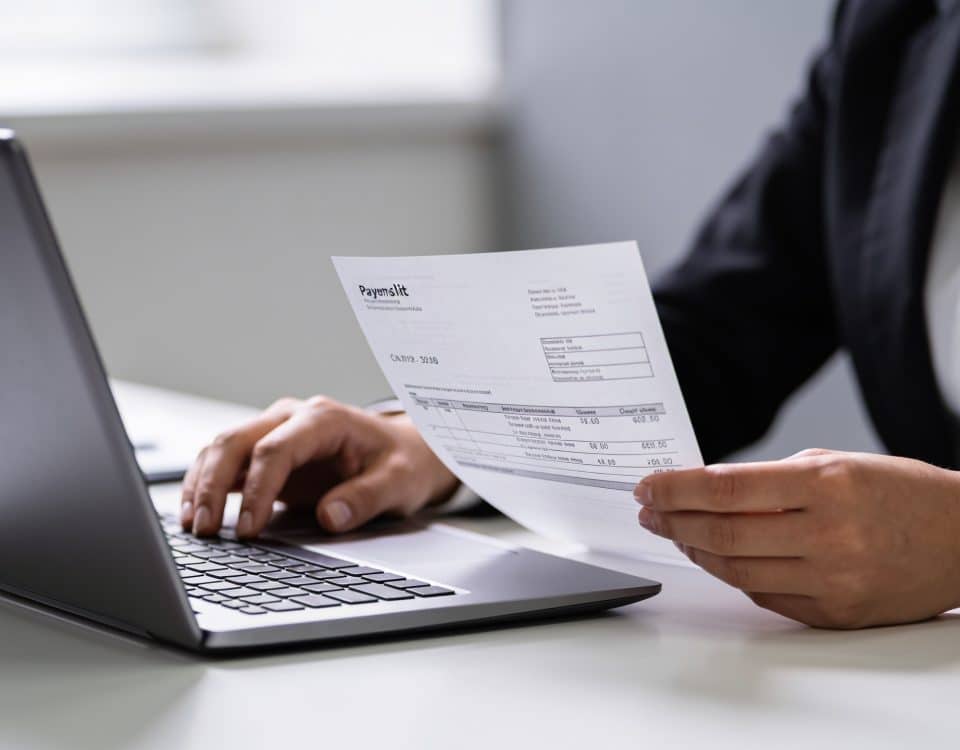 employe assis devant ordinateur consultant fiche de paie