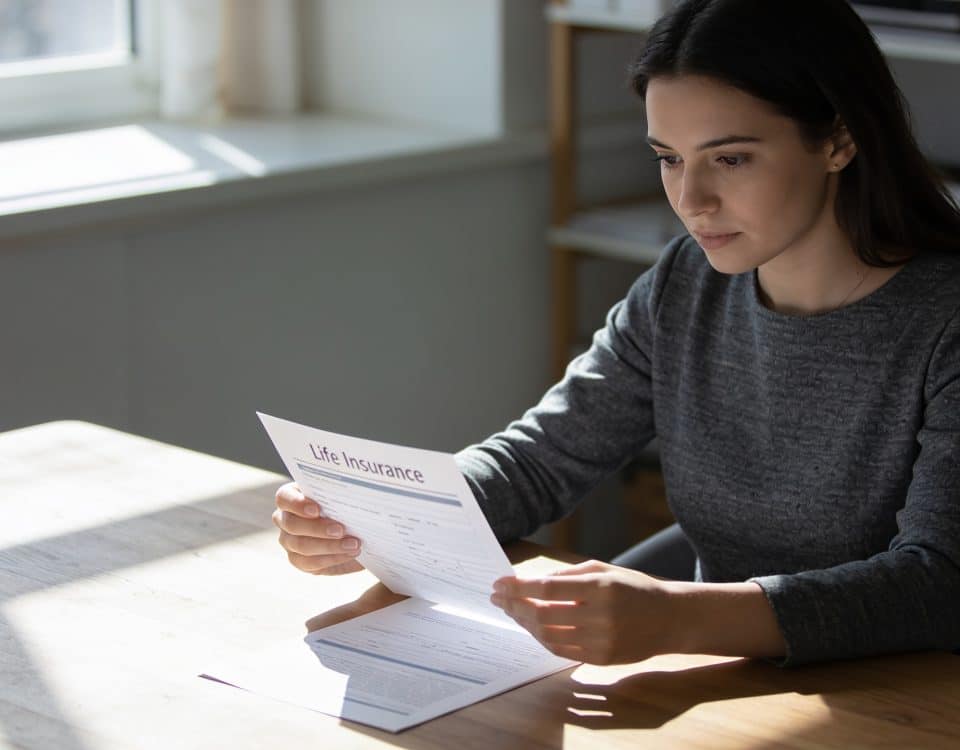 femme examine contrat assurance vie sur bureau ensoleille