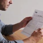 homme assis a table examinant avis dimposition