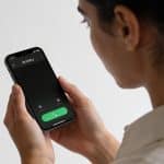 personne regardant un smartphone affichant un numero inconnu