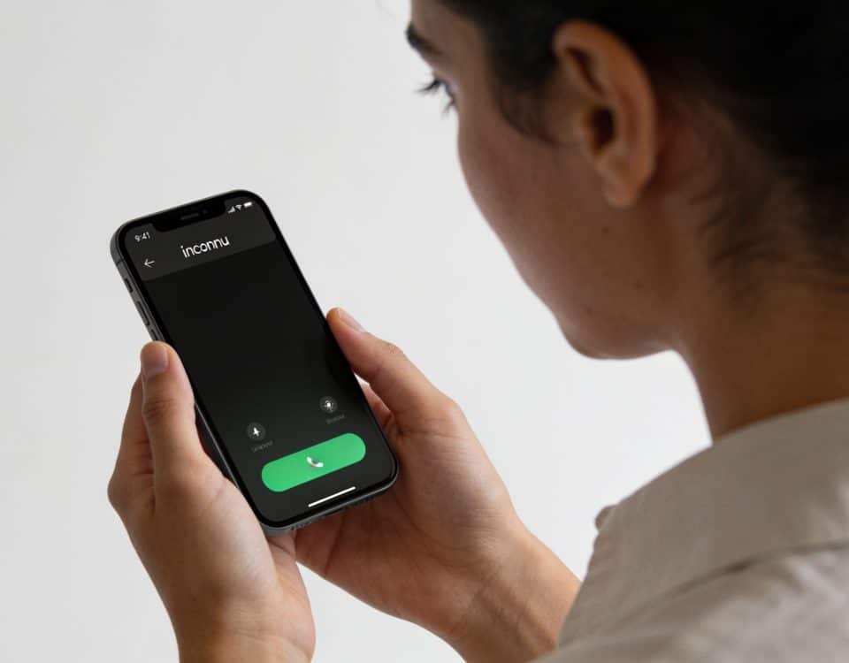 personne regardant un smartphone affichant un numero inconnu