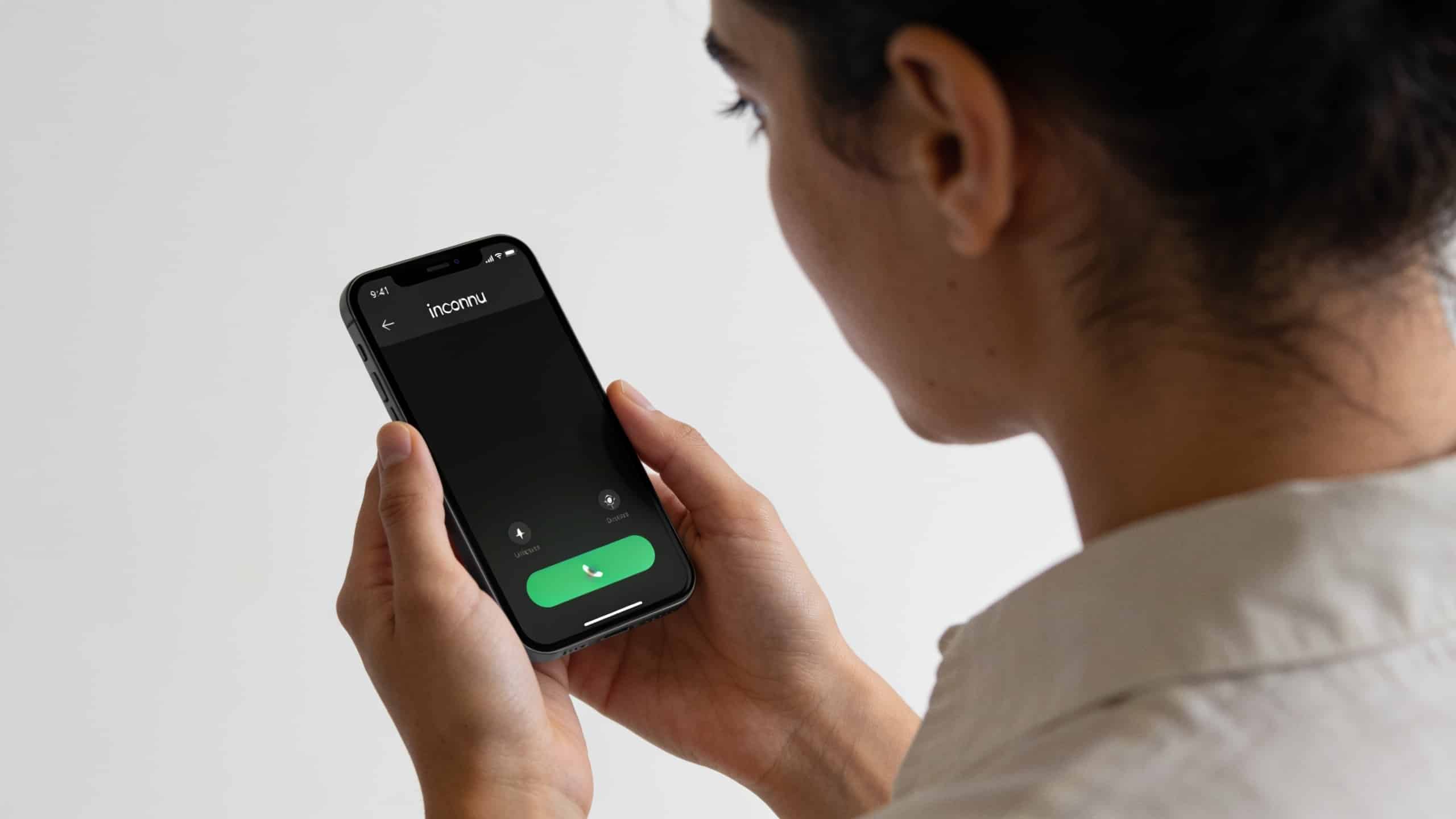 personne regardant un smartphone affichant un numero inconnu