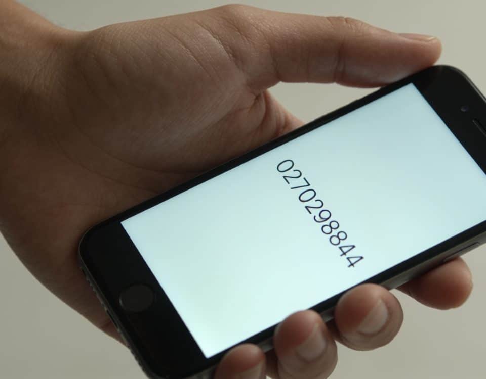smartphone en main affichant 0270298844 ecran lumineux
