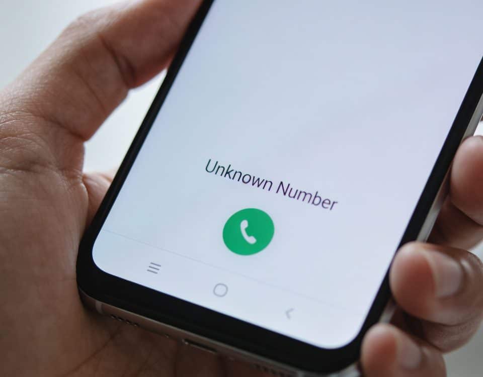 Smartphone en main affichant un numero inconnu