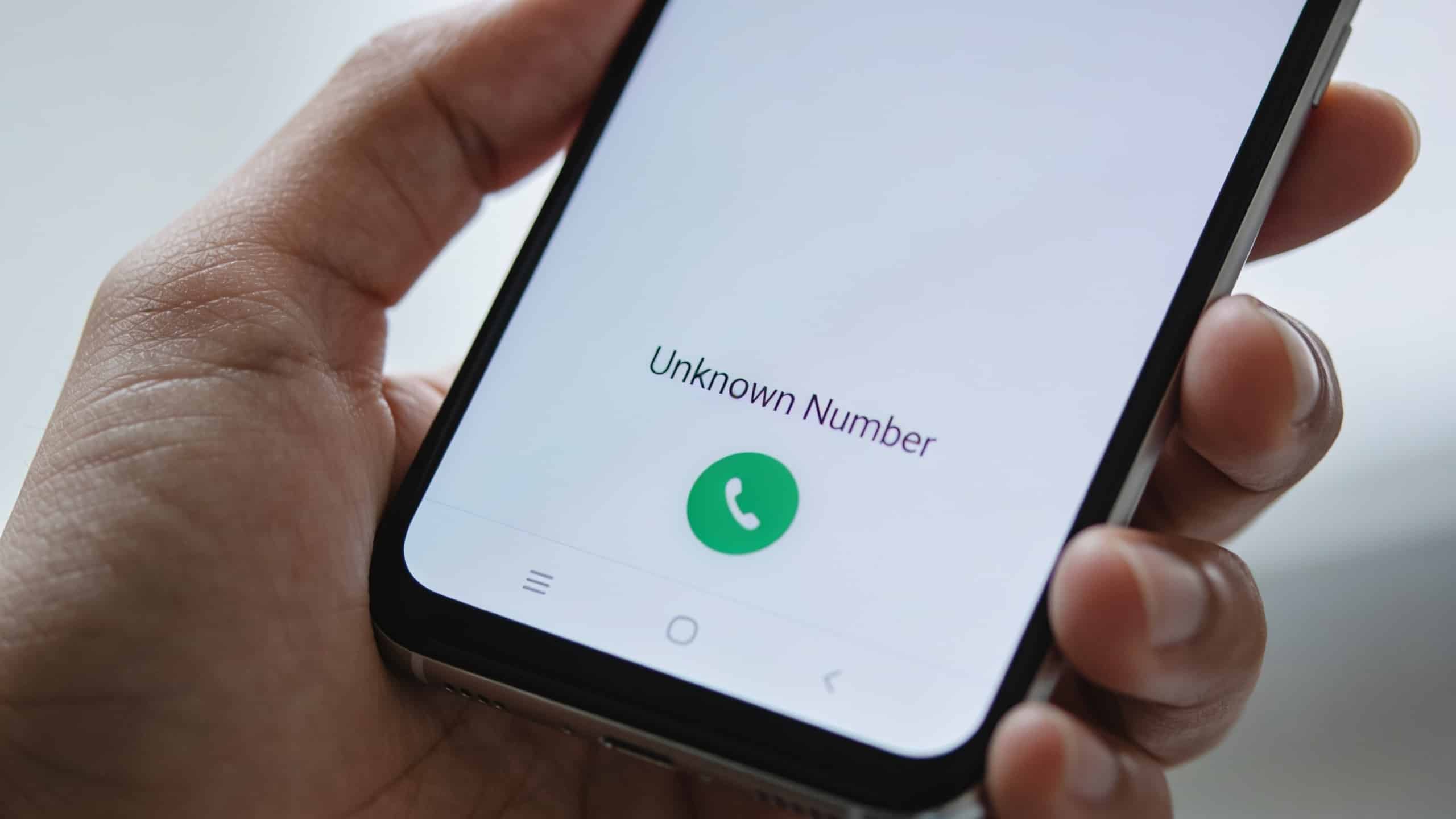 Smartphone en main affichant un numero inconnu