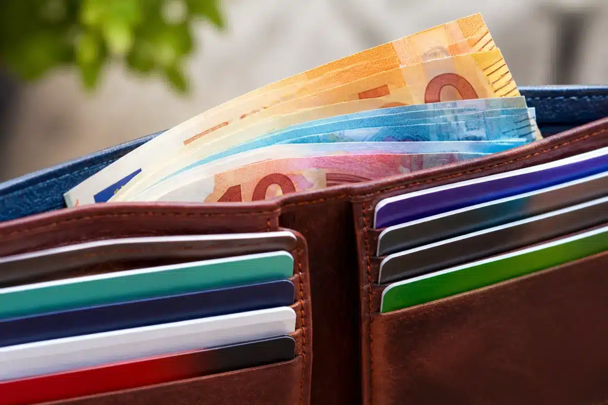 Portefeuille ouvert avec billets et cartes bancaires multicolores