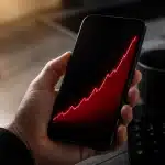 Smartphone affichant frais supplementaires croissants sur ecran noir