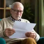Personne agee assise consultant document pension mensuelle
