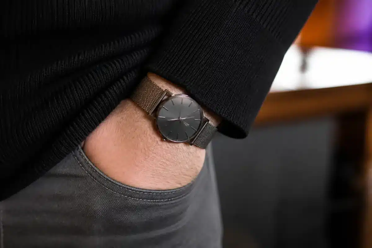 Montre luxe discrète au poignet sous manche vêtement
