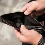 Portefeuille vide ouvert montrant des mains anxieuses sans billets