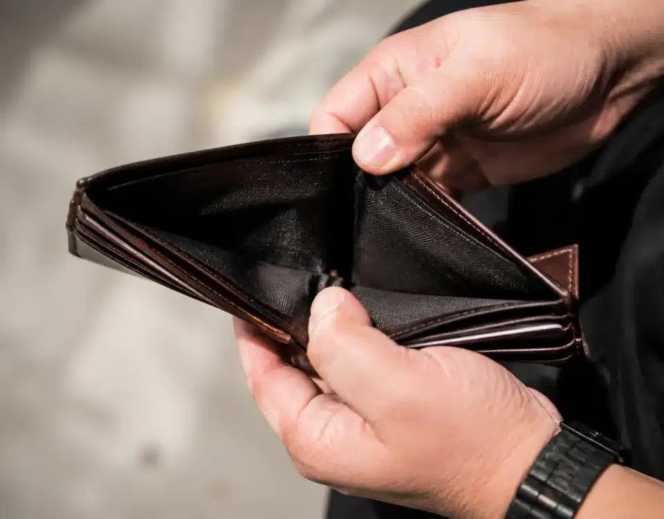 Portefeuille vide ouvert montrant des mains anxieuses sans billets