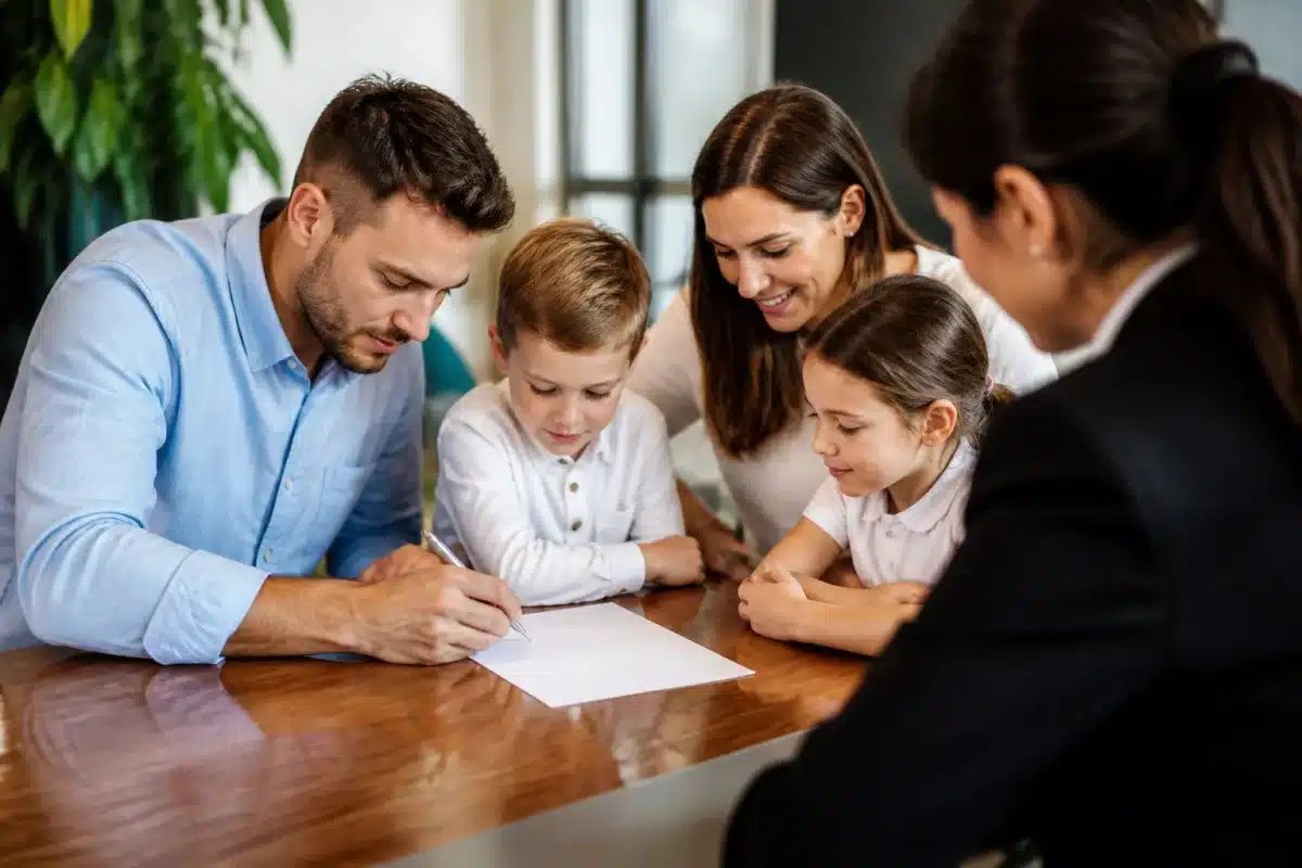 Familles avec enfants signant documents assurance ensemble