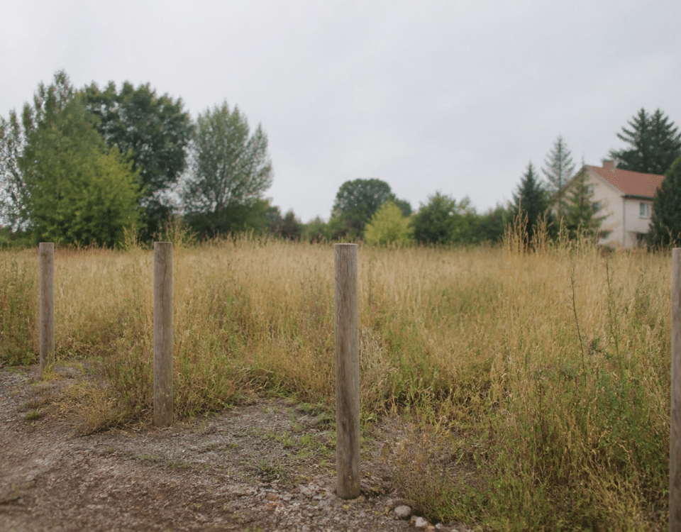 Terrain vague avec piquets delimitation et panneaux constructibles