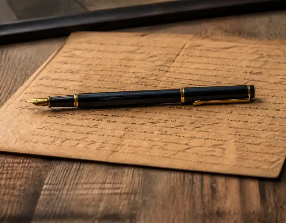 Document manuscrit sur table avec stylo posé dessus horizontalement