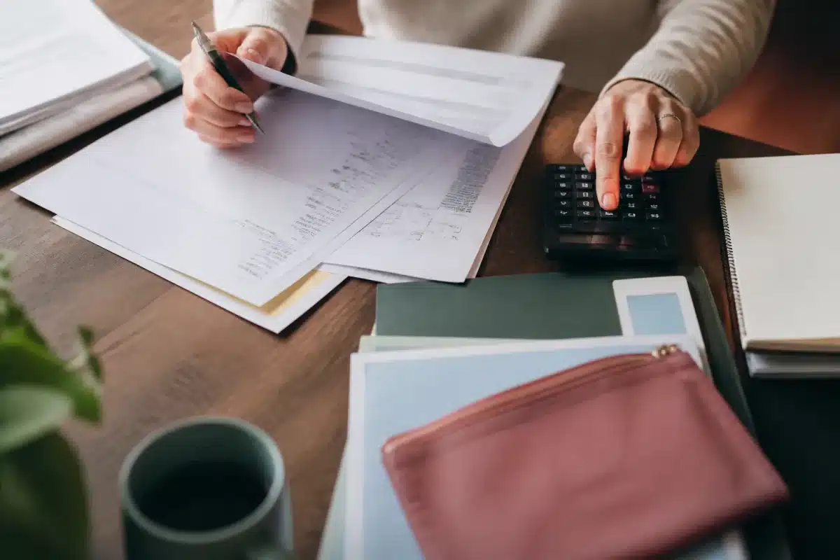 Documents administratifs étalés montrant aides sociales et calculs financiers