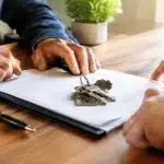 Clés d'appartement posees sur document testamentaire entre deux personnes