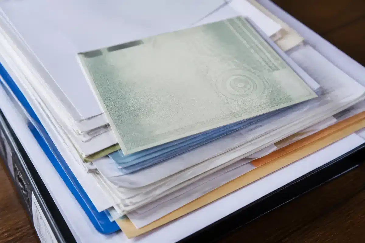 Pile de documents administratifs avec carte grise automobile visible