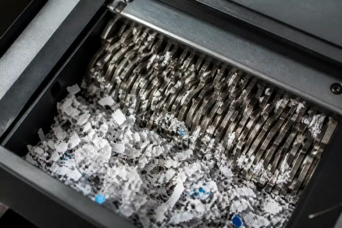 Documents dechiquetes dans une machine de destruction securisee.