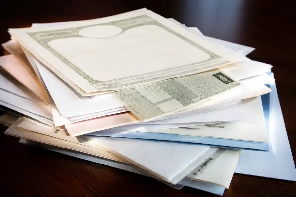 Pile de documents officiels avec certificat de décès et carte grise