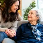 Enfant adulte tenant la main d'un parent assis dans un fauteuil
