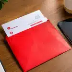 Facture électrique rouge posée sur bureau avec téléphone à côté