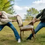 Plusieurs personnes tirent une chaise ancienne dans des directions opposées
