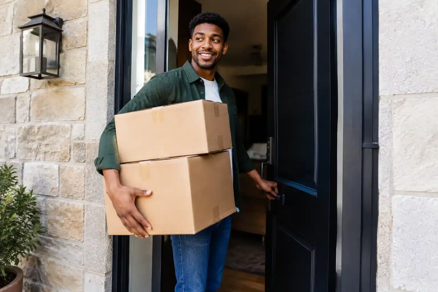 Heritier ouvrant porte maison avec boites cartons dans bras
