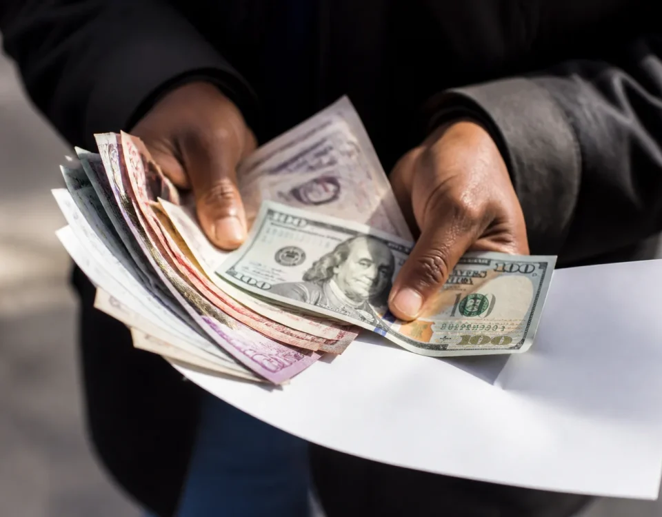 Mains tenant formulaires et billets de banque etales