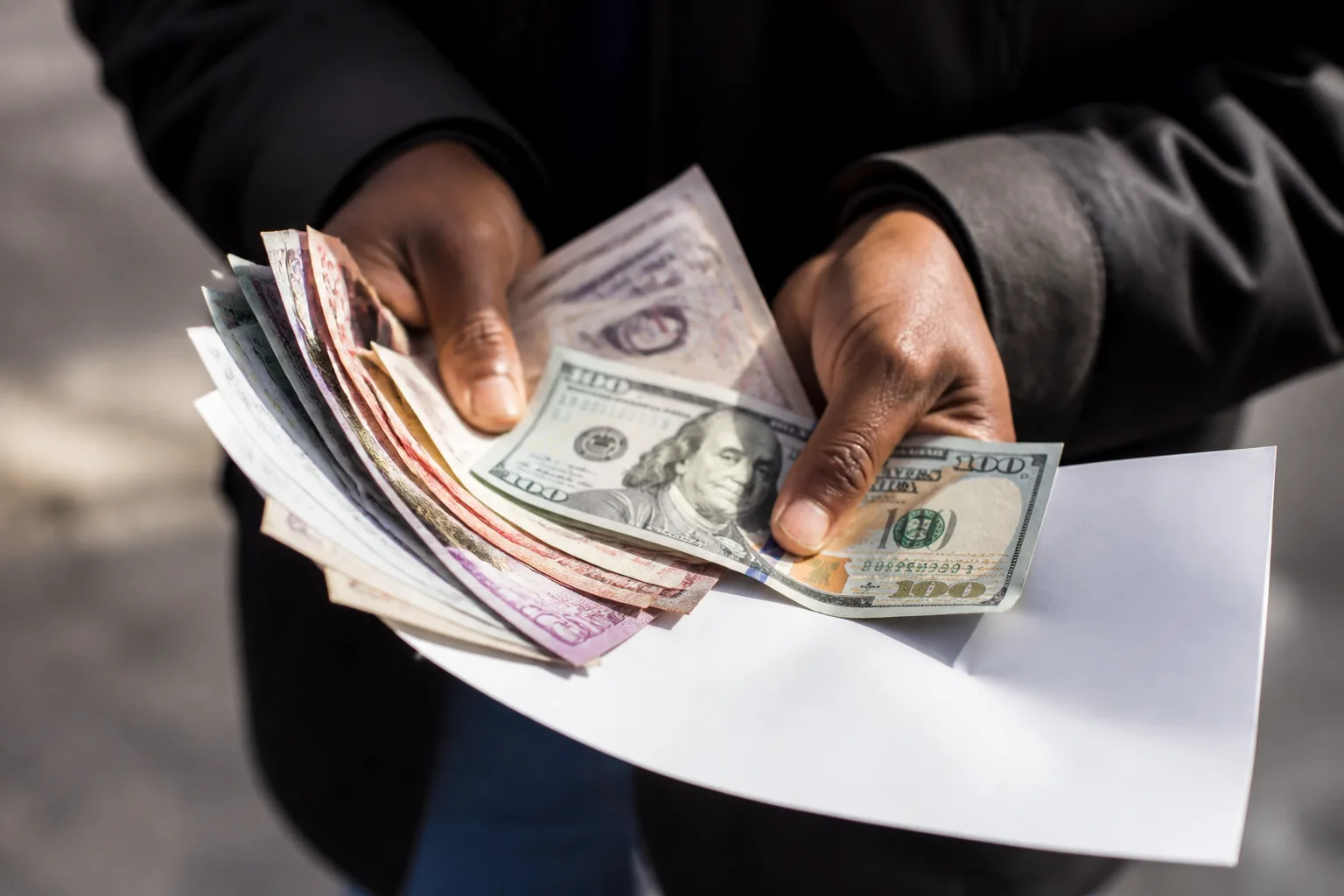 Mains tenant formulaires et billets de banque etales