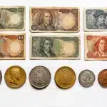 Pieces et billets anciens alignes sur surface blanche, valeur marquee