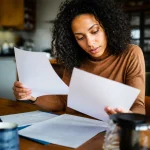 Personne assise consulte documents aide sociale administratifs