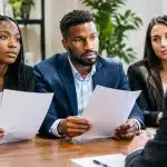 Groupe de personnes assises presentant des documents de plainte officielle