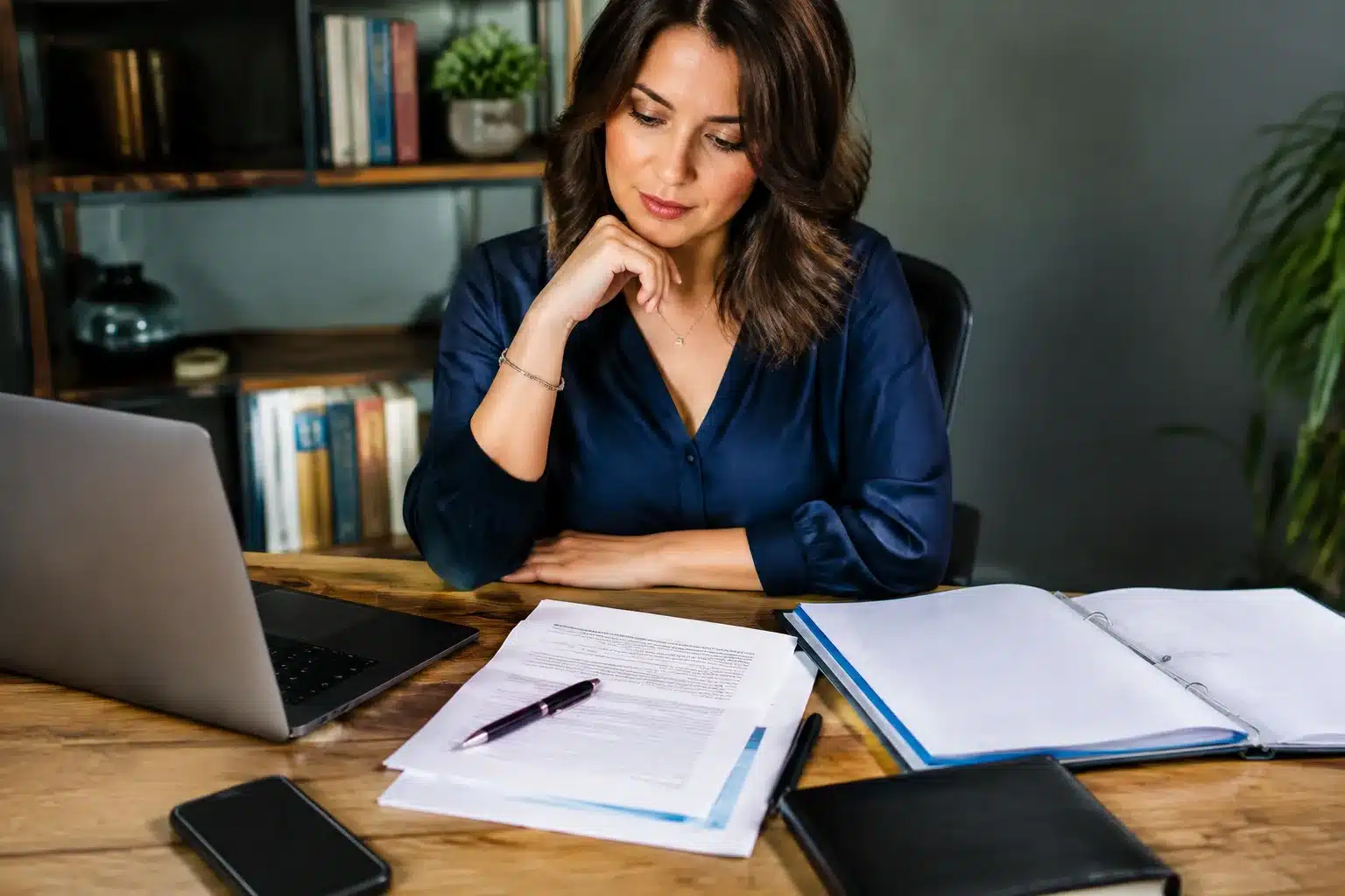 Documents bancaires et testament posés sur bureau devant personne assise