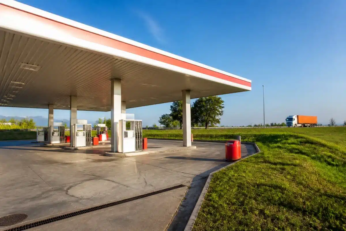 Station essence commerciale avec pompes avant échangeur autoroute