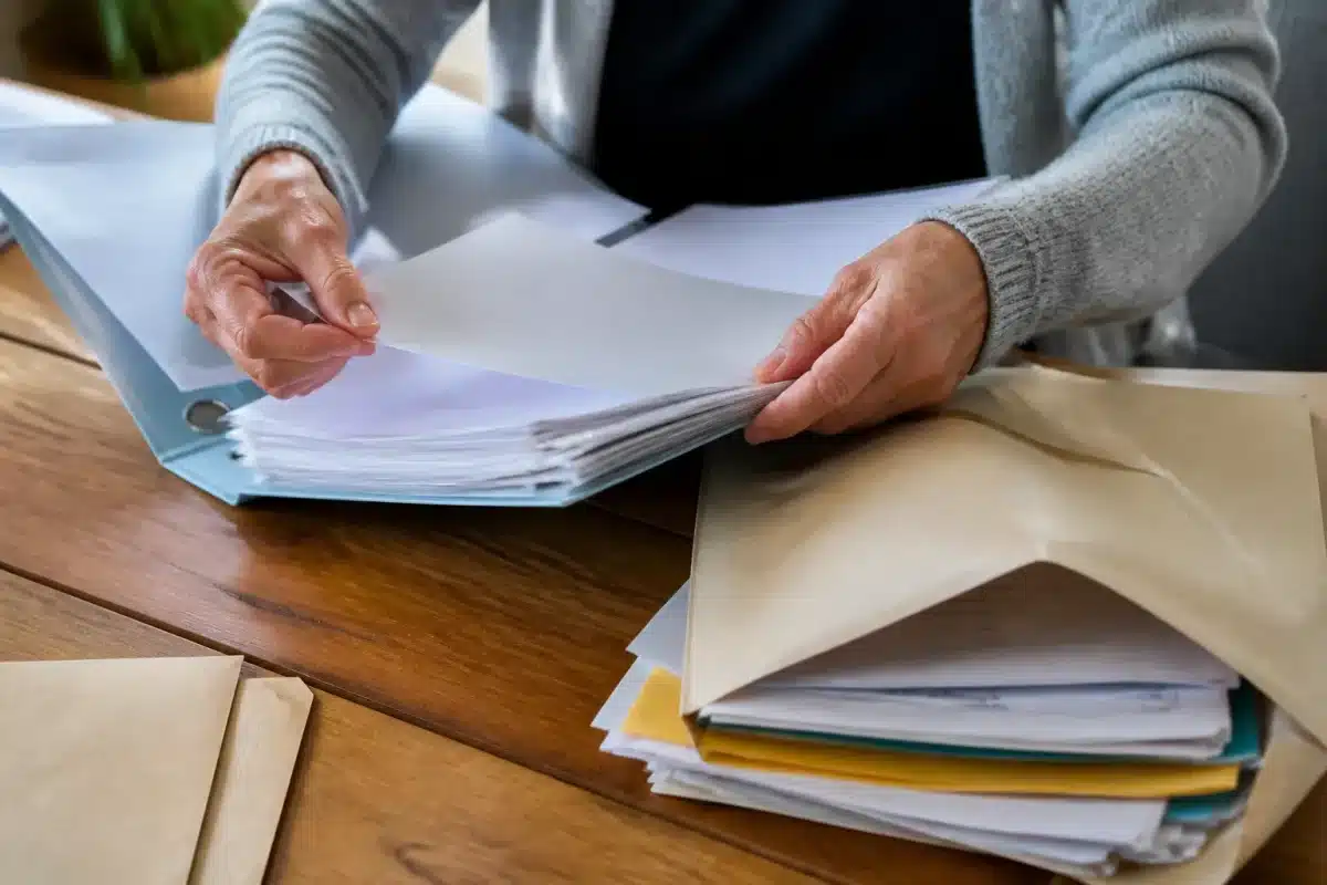 Mains triant documents importants dans classeurs et enveloppes ouvertes