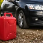 Bidon de fioul rouge pose pres d'une voiture diesel