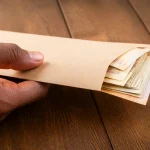 Billets de banque serres dans une enveloppe fermee