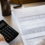 Calculatrice et fiche de paie posees sur un bureau