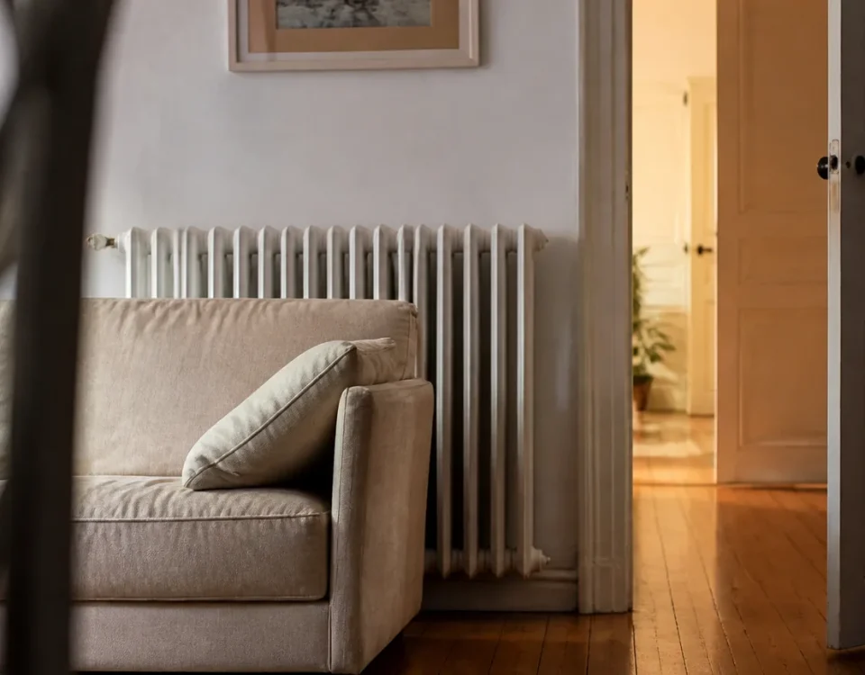 Canape pose devant radiateur, porte ouverte sur couloir