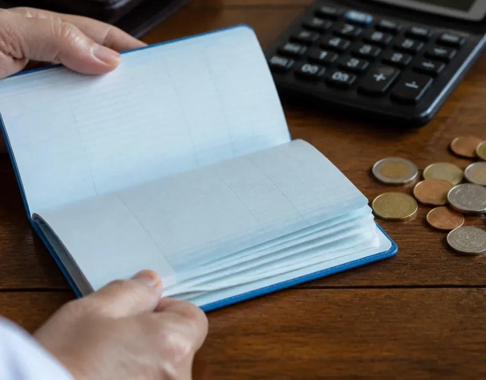 Carnet bancaire ouvert pres de pieces et calculatrice